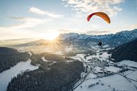 Paraglider vor winterlicher Berglandschaft, Tourismusverband Werfenweng