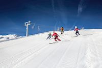 Menschen fahren eine Piste hinunter, Skifahren, Piste hinunter fahren, Spaß im Schnee, Imst Tourismus