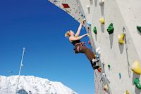 Frau klettert, Frau klettert eine Wand empor vor Bergkulisse, Imst Tourismus