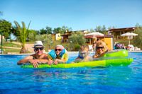 Familie auf Luftmatratze im Pool, I.D. Riva Tours