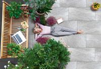 Frau liegt auf der Terrasse aus Keramik-Beton-Verbundplatten, KOLL Steine
