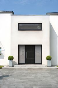 Hausansicht mit heller Fassade und dunkler Haustür mit Glas-Seitenteilen, Rodenberg