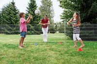 Familie spielt im Garten mit einem Ball, RAL Gütegemeinschaft Metallzauntechnik