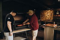 Zwei Männer grillen im Innenbereich, MOESTA-BBQ
