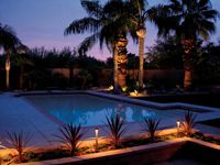 Pool mit Palmen und Beleuchtung bei Sonnenuntergang, Rainpro