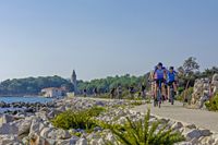 Gruppe Fahrradfahrer auf Radweg an der Küste, I.D. Riva Tours
