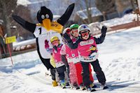 Kinder auf Skiern und ein Mensch im Pinguin-Kostüm, Kirchleitn Familien Feriendorf