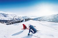 Skifahrer bei derAbfahrt, Skipiste im Sonnenschein, Skifahrer vor Bergpanorama, 