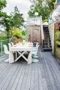 Holzterrasse, gedeckter Tisch auf Holzterrasse, Terrasse im Grünen, Kebony