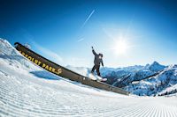 Snowboarder auf Hindernis, Snowboarder im Freiflug, Absolut Park, Snowpark, Ski amadé, Salzburger Sportwelt