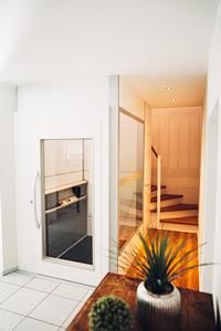 Wohnraum mit Treppe und Homelift, Ammann & Rottkord