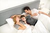 Familie kuschelt im Bett, MELLERUD