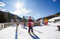 Kinder auf Skiern vor Bergkulisse, Kirchleitn Familien Feriendorf