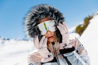 Frau mit Kapuze und Ski-Brille im Schnee, Intersport