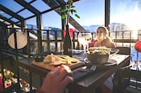 Essen auf der Almhütte, Kulinarik vor Bergpanorama, Brettljause vor Glasfront mit Blick auf die Berge, Ski- und Weingenusswoche, Ski amadé, Hochkönig
